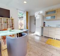 DOBROHOŠŤ- Prenájom  3i zariadeného bytu s predzáhradkou a parkingom - Interiér 3-izbového bytu s kuchynskou linkou, dreveným dekorom podlahy a jedálenským stolom.