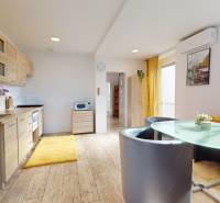 DOBROHOŠŤ- Prenájom  3i zariadeného bytu s predzáhradkou a parkingom - Kuchyňa v 3-izbovom byte s podlahou s dreveným dekorom a jedálenským stolom.