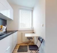2 byty v 1 už s nájomníkmi | okamžitý príjem 1600 €/mes | 4.87% - Kuchyňa v 3-izbovom byte s podlahou s dreveným dekorom a stolovaním pre dve osoby.