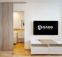 2 byty v 1 už s nájomníkmi | okamžitý príjem 1600 €/mes | 4.87% - Obývacia izba s televízorom a podlahou s dreveným dekorom v 3-izbovom byte.