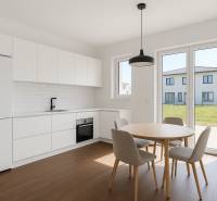 5-izbový dom s predzáhradkou pre rodiny v pokojnej zóne - Kuchyňa v 5 a viac izbovom byte s bielymi skrinkami a podlahou s dreveným dekorom.