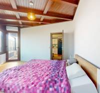 2 byty v 1 už s nájomníkmi | okamžitý príjem 1770€/mes | 4.08% - Spálňa s posteľou, podlahou s dreveným dekorom a veľkými oknami v 5 a viac izbovom byte.