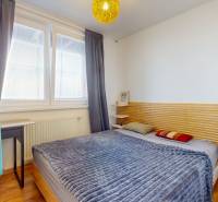 2 byty v 1 už s nájomníkmi | okamžitý príjem 1770€/mes | 4.08% - Útulná spálňa s posteľou, nočným stolíkom a podlahou s dreveným dekorom v 5 a viac izbovom byte.