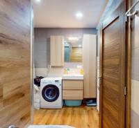 2 byty v 1 už s nájomníkmi | okamžitý príjem 1770€/mes | 4.08% - Kúpeľňa s práčkou a skrinkami v 5 a viac izbovom byte, podlaha s dreveným dekorom.