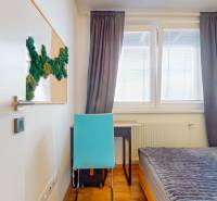 2 byty v 1 už s nájomníkmi | okamžitý príjem 1770€/mes | 4.08% - Izba s posteľou, stolíkom, modrou stoličkou a dekoráciou na stene v 5-izbovom byte.
