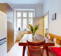 5iz byt s vysokými stropmi a výťahom pri EUROVEA | 136 m²  - Kuchyňa s dreveným stolom, kvetinovou výzdobou a podlahou s dreveným dekorom.