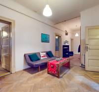 5iz byt s vysokými stropmi a výťahom pri EUROVEA | 136 m² - Obývacia izba v 5 a viac izbovom byte s podlahou s dreveným dekorom a sedačkou.