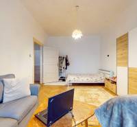 5iz byt s vysokými stropmi a výťahom pri EUROVEA | 136 m² - Obývacia izba s podlahou s dreveným dekorom, pohovkou, posteľou a veľkou skriňou.