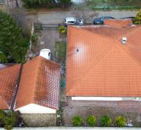 4-izbový samostatne stojaci dom s garážou | Podunajské Biskupice - Rodinný dom na Jonatánovej ulici v Bratislave - Podunajských Biskupiciach s červenou strechou a autom.