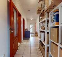 4-izbový samostatne stojaci dom s garážou | Podunajské Biskupice - Chodba v rodinnom dome, balíky na policiach, dlaždicová podlaha, drevené dvere.