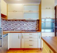 2iz byt v novostavbe s parkovaním | Podunajské Biskupice | 57m2 - Kuchyňa v 2-izbovom byte s podlahou s dreveným dekorom a vstavanými spotrebičmi.