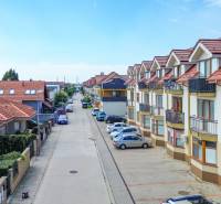 2iz byt v novostavbe s parkovaním | Podunajské Biskupice | 57m2 - Radové domy na Perličkovej ulici v Bratislave – Podunajských Biskupiciach, so zaparkovanými autami.