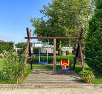 2iz byt v novostavbe s parkovaním | Podunajské Biskupice | 57m2 - Detské ihrisko s hojdačkami a trampolínou, obklopené zeleňou v Bratislave na Perličkovej ulici.