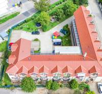 2iz byt v novostavbe s parkovaním | Podunajské Biskupice | 57m2 - Dvojposchodový bytový komplex s červenou strechou na Perličkovej ulici v Bratislave - Podunajských Biskupiciach.