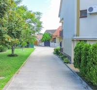 2iz byt v novostavbe s parkovaním | Podunajské Biskupice | 57m2 - Dvor s parkoviskom a stromami na Perličkovej ulici v Bratislave - Podunajských Biskupiciach.