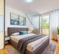 2iz byt v novostavbe s parkovaním | Podunajské Biskupice | 57m2 - Svetlá spálňa v 2-izbovom byte s podlahou s dreveným dekorom a veľkým oknom.
