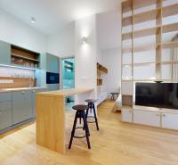 | Butiková 1,5i rezidencia s balkónom | Historická mestská - Kuchyňa spojená s obývačkou v 2-izbovom byte, podlaha s dreveným dekorom, zabudovaná TV.