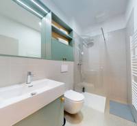 | Butiková 1,5i rezidencia s balkónom | Historická mestská - Kúpeľňa v 2-izbovom byte s umývadlom, sprchovým kútom a pastelovými skrinkami.