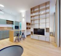 | Butiková 1,5i rezidencia s balkónom | Historická mestská - Obývacia izba 2-izbového bytu s otvorenou kuchyňou a podlahou s dreveným dekorom.