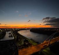 | E2Tower | 20.poschodie | 2i byt | panoramatický výhľad |  - Nočný pohľad na rieku a most v Bratislave z ulice Pribinova.