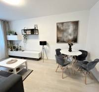 NA PREDAJ ŠTÝLOVÝ 2- IZBOVÝ BYT, 50m2, SÍDLISKO 2, PREŠOV - Interiér 2-izbového bytu so stolom, stoličkami a dekoráciami, podlaha s dreveným dekorom.