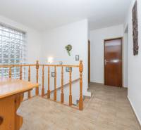 RD s VEĽKÝM POZEMKOM V SRDCI PRÍRODY, Tŕstie - Rodinný dom s dreveným stolom, zábradlím a veľkým oknom z luxferov.