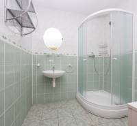 RD s VEĽKÝM POZEMKOM V SRDCI PRÍRODY, Tŕstie - Kúpeľňa v rodinnom dome s oblým sprchovým kútom, umývadlom a zelenými obkladačkami.