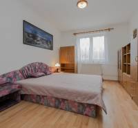 RD s VEĽKÝM POZEMKOM V SRDCI PRÍRODY, Tŕstie - Spálňa v rodinnom dome s podlahou s dreveným dekorom, manželskou posteľou a nábytkom.