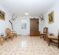 RD s VEĽKÝM POZEMKOM V SRDCI PRÍRODY, Tŕstie - Interiér rodinného domu so sedačkou z ratanu, stoličkami, ozdobnými paroziami a obrazmi.