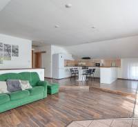 4-izbový podkrovný byt s nebytovým priestorom v obci Pavlice - Interiér rodinného domu s pohovkou, kuchynským kútom a podlahou s dreveným dekorom.