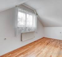 4-izbový podkrovný byt s nebytovým priestorom v obci Pavlice - Izba v rodinnom dome s oknom a podlahou s dreveným dekorom.