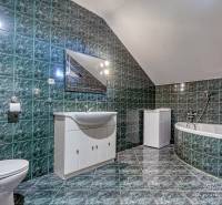 4-izbový podkrovný byt s nebytovým priestorom v obci Pavlice - Kúpeľňa v rodinnom dome s vaňou, zelenými kachličkami a bielym nábytkom.