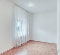 4-izbový podkrovný byt s nebytovým priestorom v obci Pavlice - Svetlá miestnosť s podlahou s dreveným dekorom a záclonami v rodinnom dome.