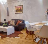 Vkusný, moderný 2 izb, klíma, 870 s ener., Sibírska ul./Nové Mesto - Interiér 2-izbového bytu s podlahou s dreveným dekorom, koženými sedačkami a okrúhlym stolom.