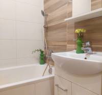 Vkusný, moderný 2 izb, klíma, 870 s ener., Sibírska ul./Nové Mesto - Kúpeľňa v 2-izbovom byte s vaňou a umývadlom, obkladaná dlaždicami s dreveným dekorom.