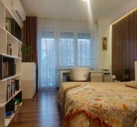 Vkusný, moderný 2 izb, klíma, 870 s ener., Sibírska ul./Nové Mesto - Spálňa v 2-izbovom byte s podlahou s dreveným dekorom, knižnica a písací stôl.