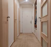 Vkusný, moderný 2 izb, klíma, 870 s ener., Sibírska ul./Nové Mesto - Chodba s podlahou s dreveným dekorom v 2-izbovom byte; biele dvere s úložným priestorom.