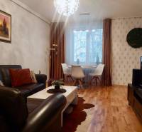Vkusný, moderný 2 izb, klíma, 870 s ener., Sibírska ul./Nové Mesto - Obývačka s koženou sedačkou, jedálenským stolom a podlahou s dreveným dekorom v 2-izbovom byte.