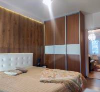 Vkusný, moderný 2 izb, klíma, 870 s ener., Sibírska ul./Nové Mesto - Spálňa s podlahou s dreveným dekorom, posuvnými skriňami a prechodom do obývačky v 2-izbovom byte.