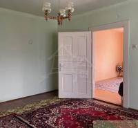 Vidiecky dom v gemerskej obci Bretka - Izba v rodinnom dome s kobercom, bielymi dverami a lustrom.