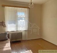 Vidiecky dom v gemerskej obci Bretka - Izba v rodinnom dome s pohovkou, oknom a podlahou s dreveným dekorom.