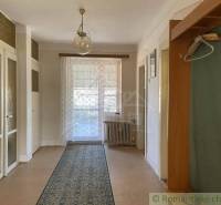 Vidiecky dom v gemerskej obci Bretka - Interiér rodinného domu s podlahou s dreveným dekorom, závesom a kobercom.