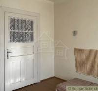 Vidiecky dom v gemerskej obci Bretka - Interiér rodinného domu s bielymi dverami, obkladom a podlahou s dreveným dekorom.