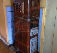 Pôvodná goralská drevenica, Osturňa - Kachľová pec v rodinnom dome s podlahou s dreveným dekorom.