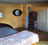 Pôvodná goralská drevenica, Osturňa - Rustikálna izba s kachľovou pecou a posteľami v rodinnom dome.