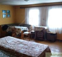 Pôvodná goralská drevenica, Osturňa - Útulná izba s dreveným dekorom, oknami, stolom a posteľou v rodinnom dome.