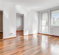 NEZARIADENÝ 2,5-izb.byt, 11m2 LODŽIA, BA IV., Červeňákova - Svetlý obývací priestor v 3-izbovom byte s podlahou s dreveným dekorom a veľkými oknami.