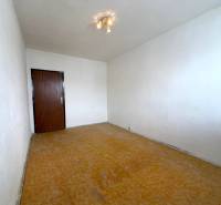 Predaj 2 - izbového bytu v Banskej Štiavnici - Izba s bielymi stenami a podlahou s dreveným dekorom v 2-izbovom byte.