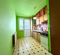 Predaj 2 - izbového bytu v Banskej Štiavnici - Kuchyňa v 2-izbovom byte s linkou, zelenými stenami a čiernobielou podlahou.