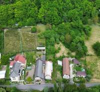 Predaj domu v Janovej Lehote - Rodinné domy obklopené zeleňou v Janovej Lehote, záhrady a lesy v pozadí.